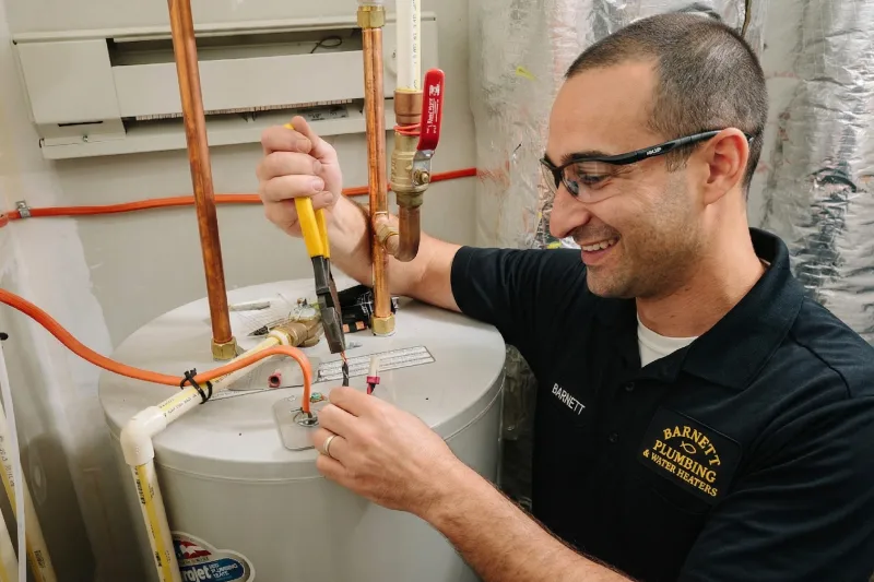 Barnett Plumbing technician installing water heater connections with copper piping and tools