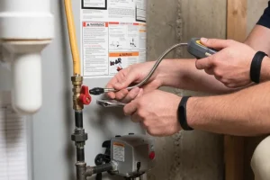 Plumber inspecting water heater connections with diagnostic tool