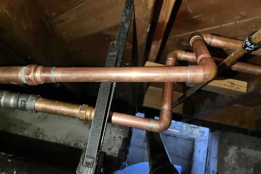 New copper water lines installed in a crawl space during a repiping project