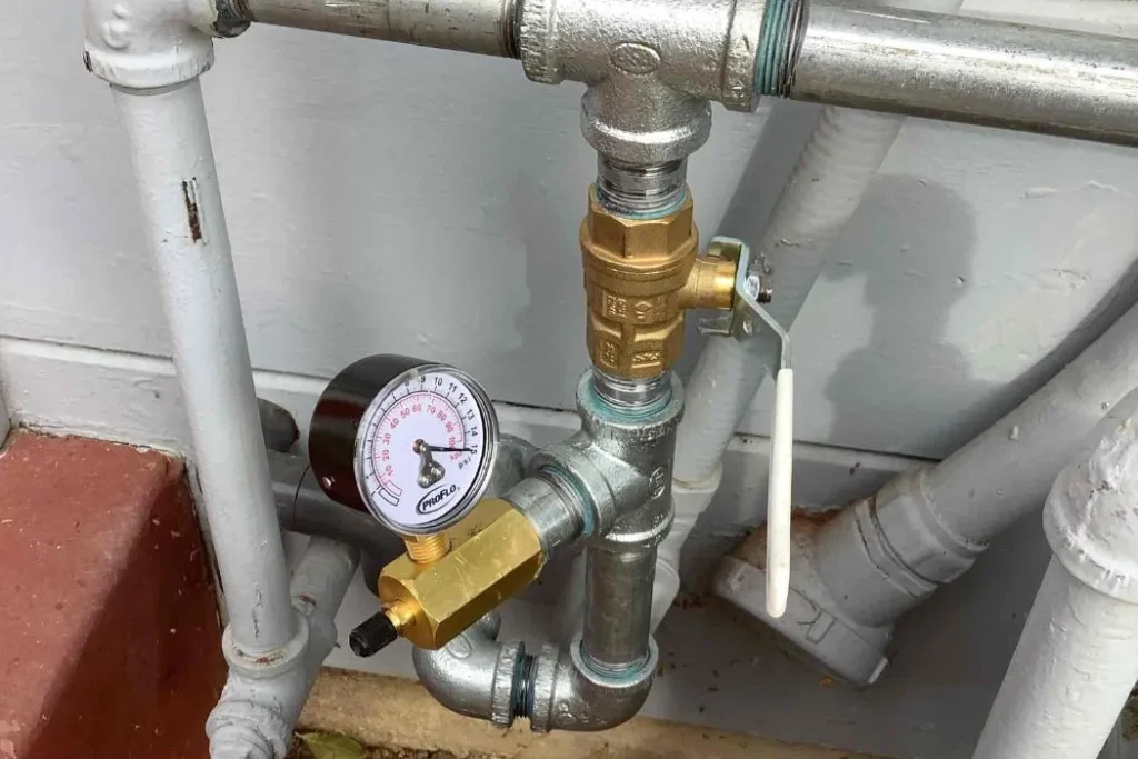 New gas line piping with a pressure test gauge at a residential gas meter