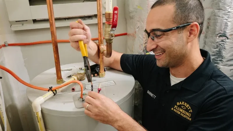 Barnett Plumbing technician installing water heater connections with copper piping and tools